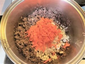 Adding Carrots and Onions to the Browned Sausage