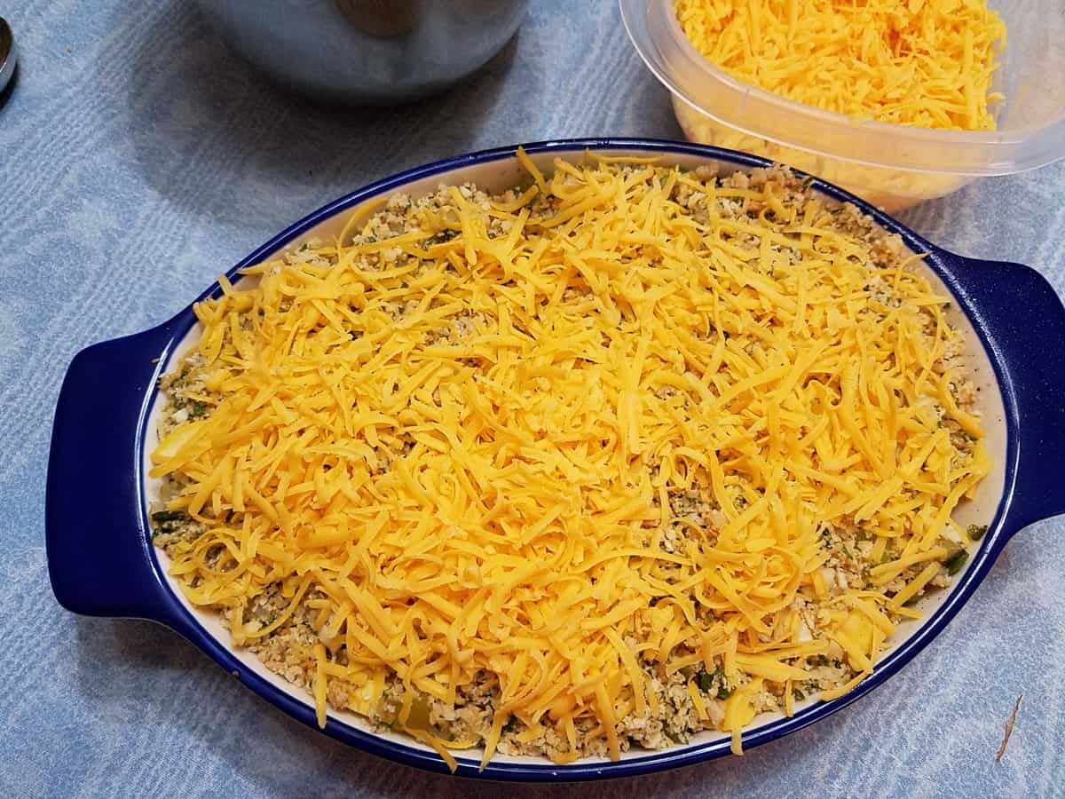 Topping the Casserole with Shredded Cheddar Cheese