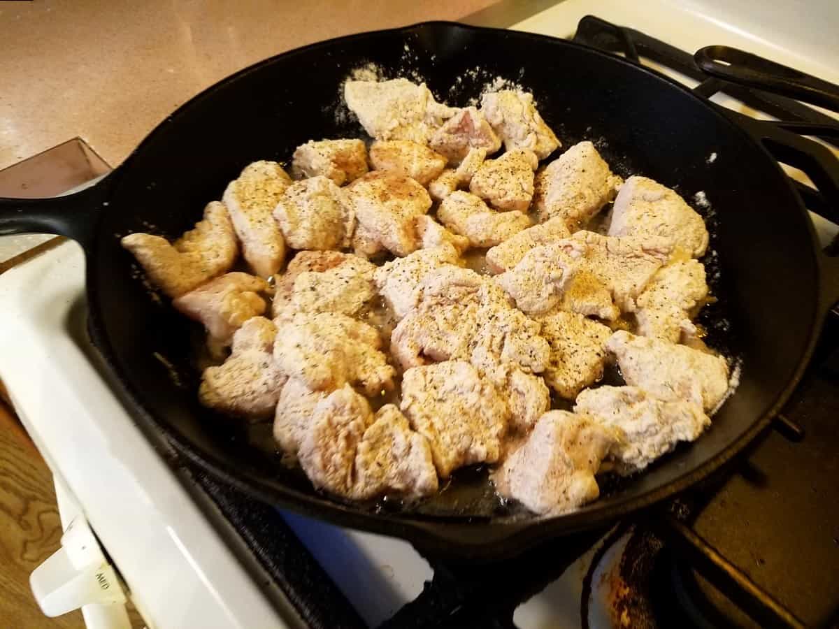 Cook Floured Chicken Pieces in a Cast Iron Skillet with Hot Oil