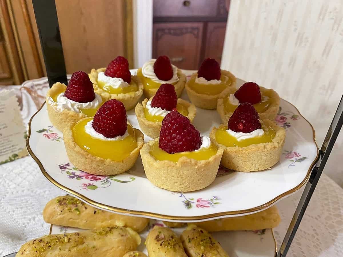 Serving Lemon Tarts with Raspberries at a Tea Party