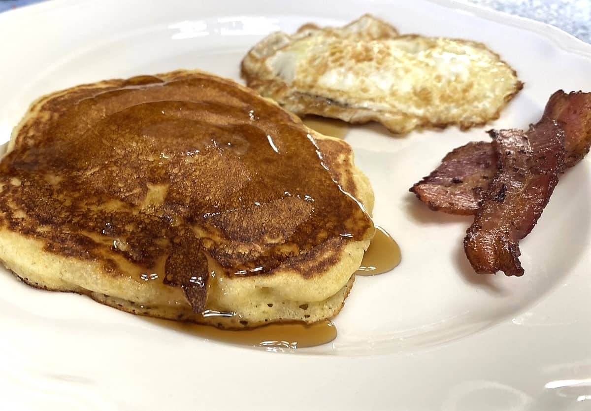 Serving Pancakes with Maple Syrup, Eggs, and Bacon