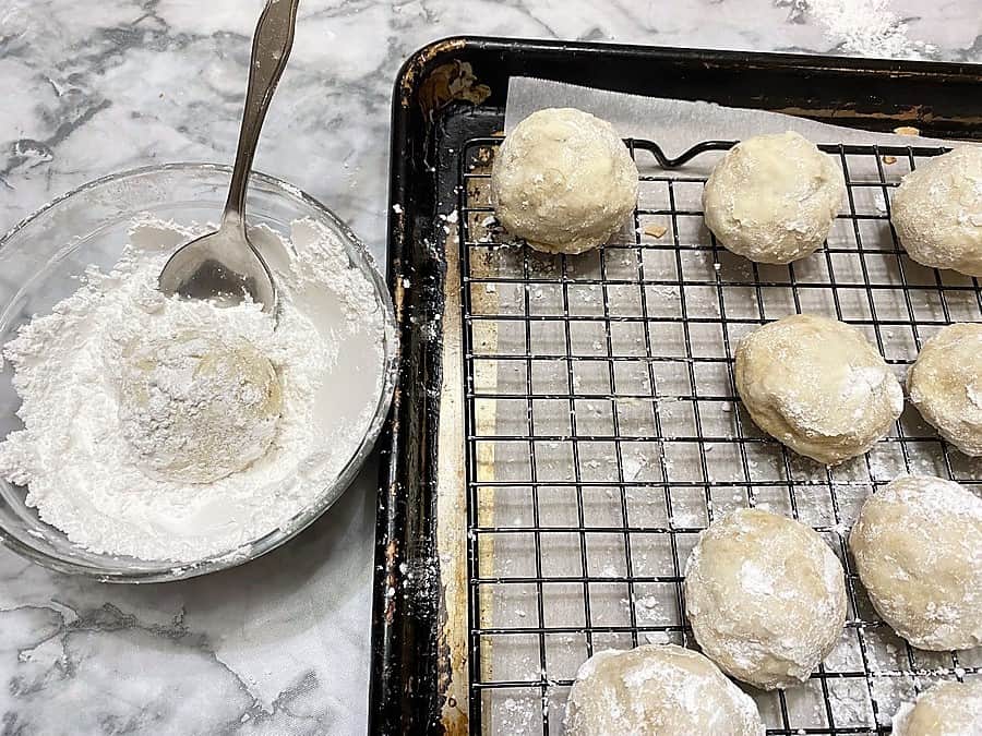 Rolling Baked Cookies into Powdered Sugar