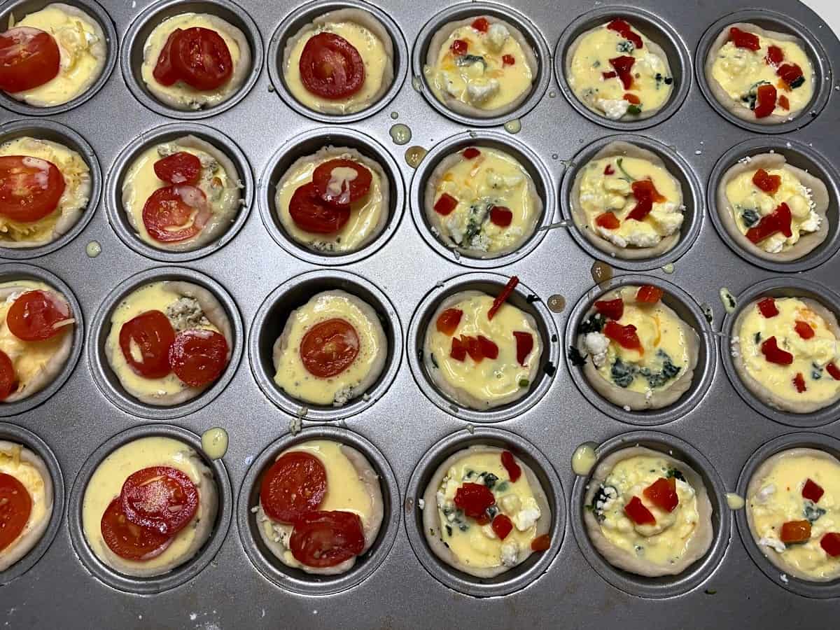 Top Mini Muffin Cups with Halved Tomatoes and Chopped Pimento