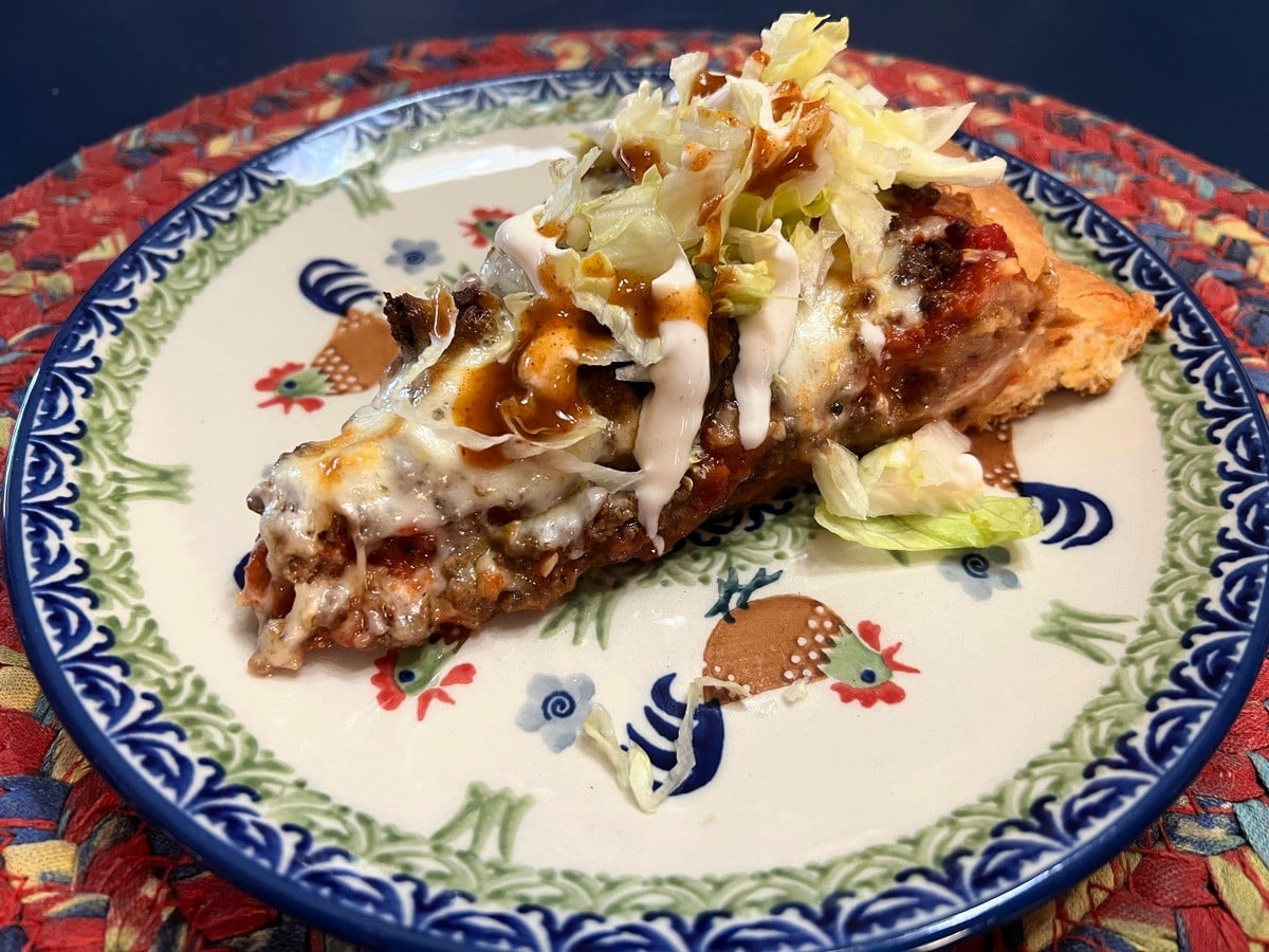 Sliced Pizza Served with Lettuce, Lime Crema, and Hot Sauce on Polish Pottery Plates - Chicken Dance Pattern